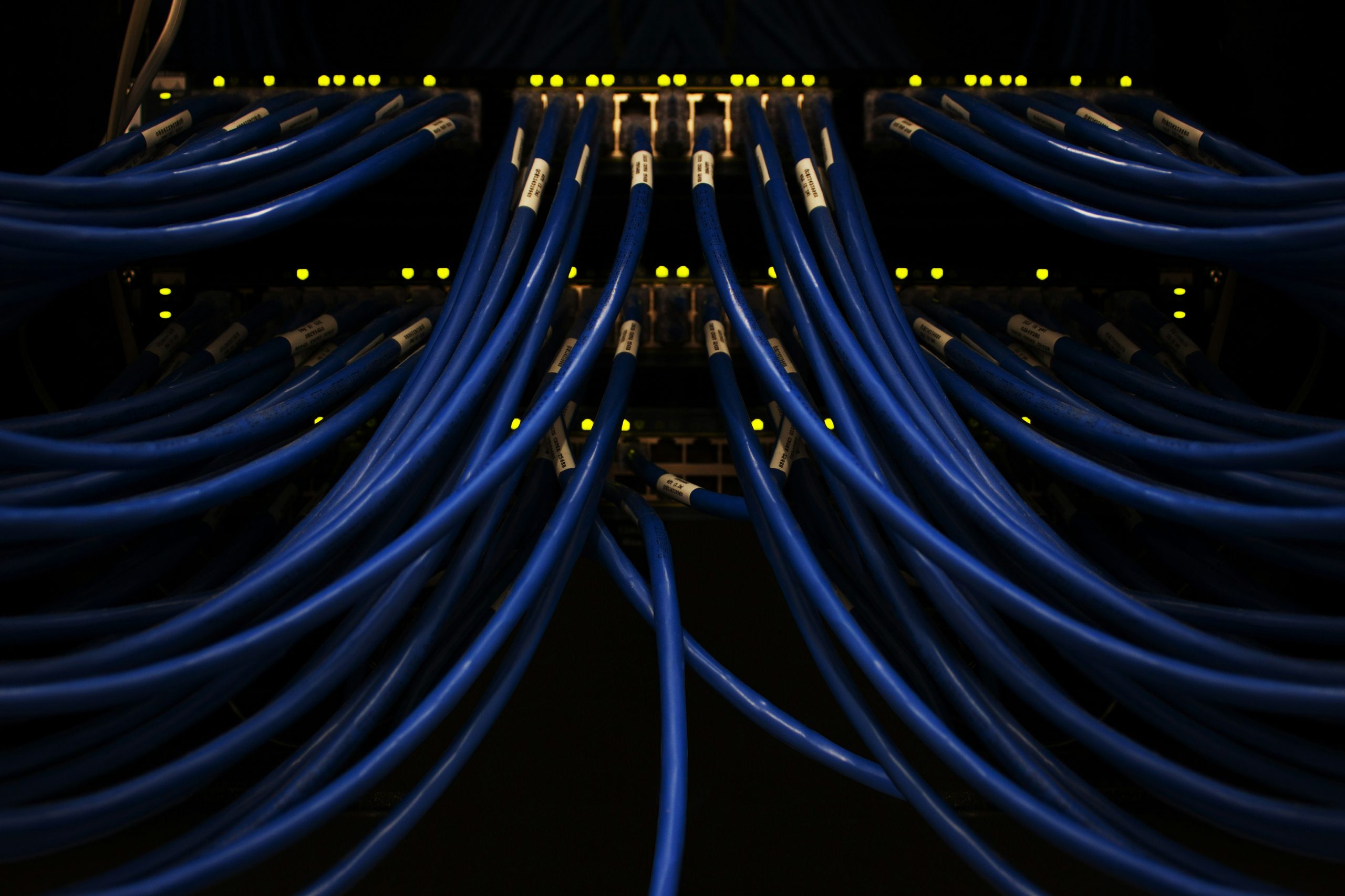 Multiple blue Ethernet cables connected to a glowing server, indicative of residential proxy servers used for web scraping.
